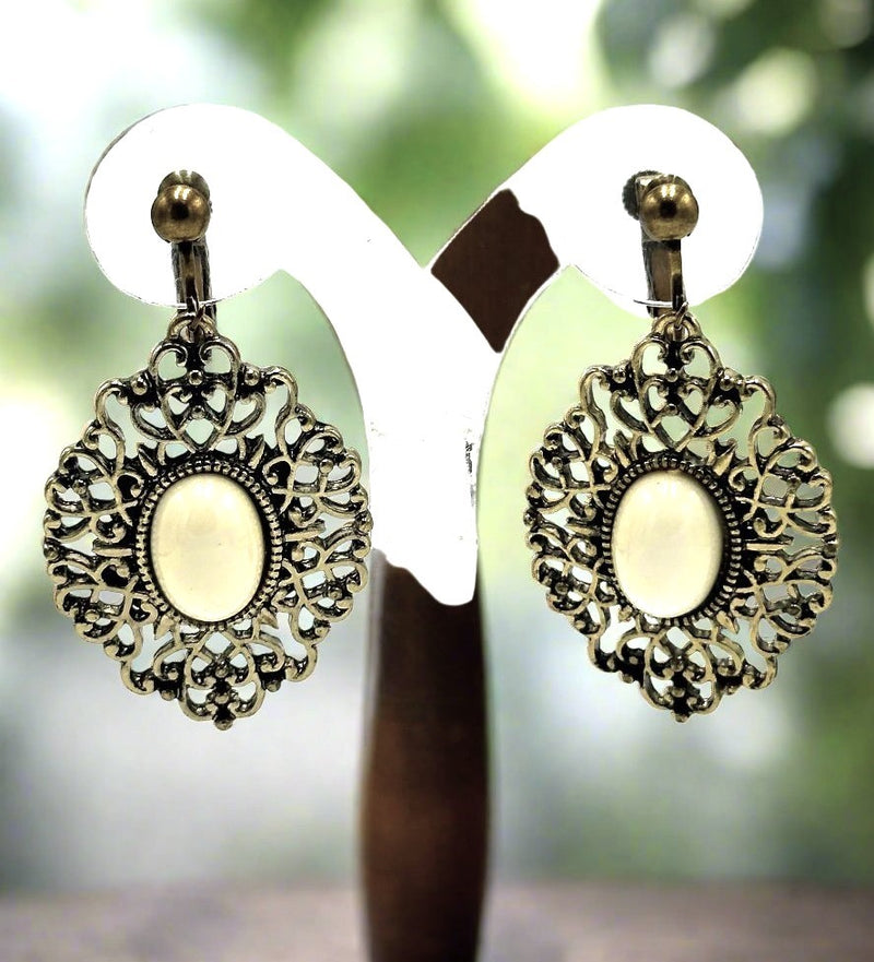 Clip on 2 1/4" brass and white stone dangle earrings with cutout edges