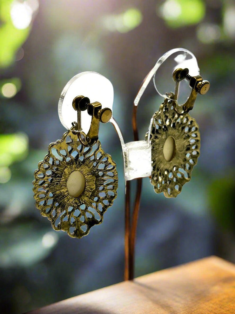 Clip on 2 1/4" brass and white stone dangle earrings with cutout edges