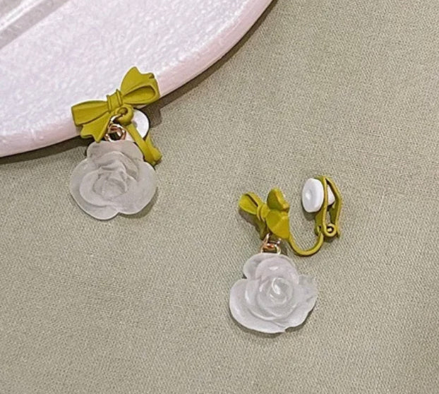Clip on 1 1/4" gold, green bow and clear white dangle flower earrings