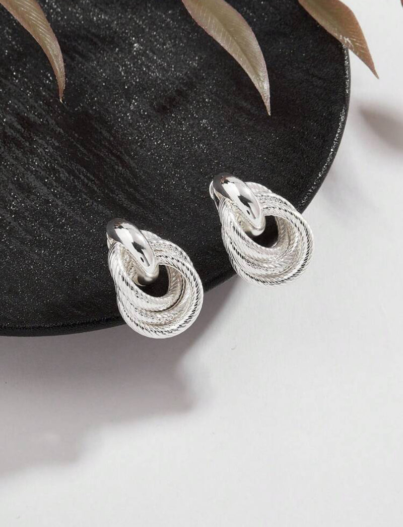 Pierced 1 1/4" silver textured knot button style earrings