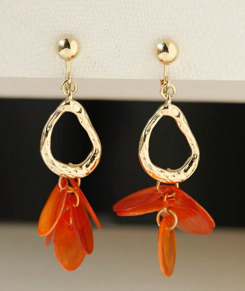 Clip on 2 1/2" gold odd shaped hoop earrings with orange shell circles