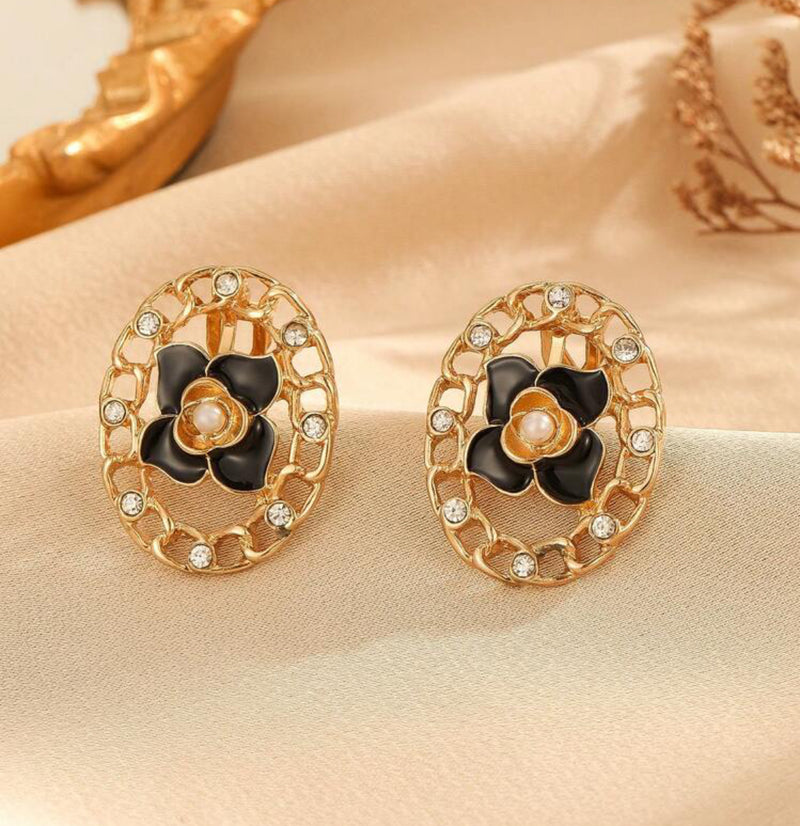 Clip on 1 3/4" gold cutout black flower earrings w/center pearl and clear stones
