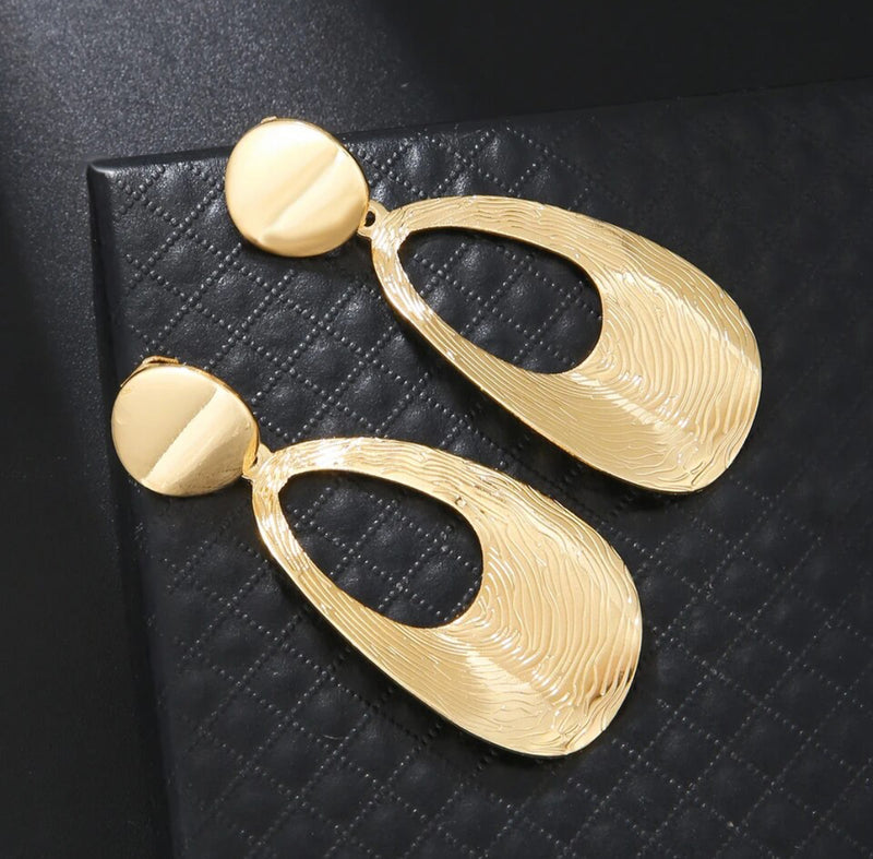 Clip on 2 3/4" shiny gold textured bent cutout oval dangle earrings