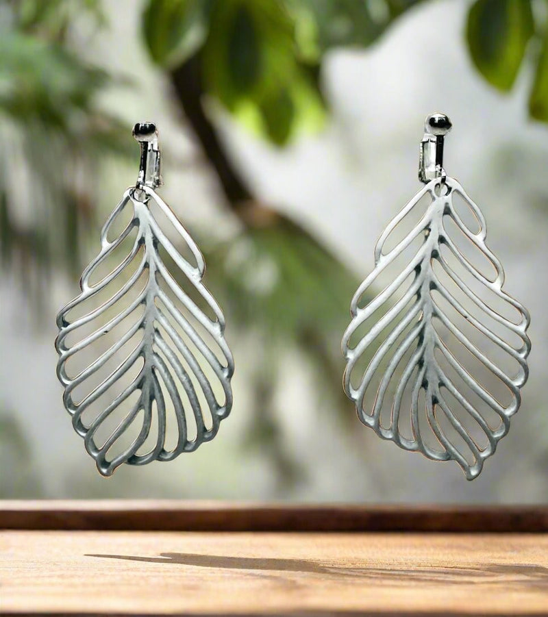 Clip on 2 1/2" silver and white cutout leaf dangle earrings