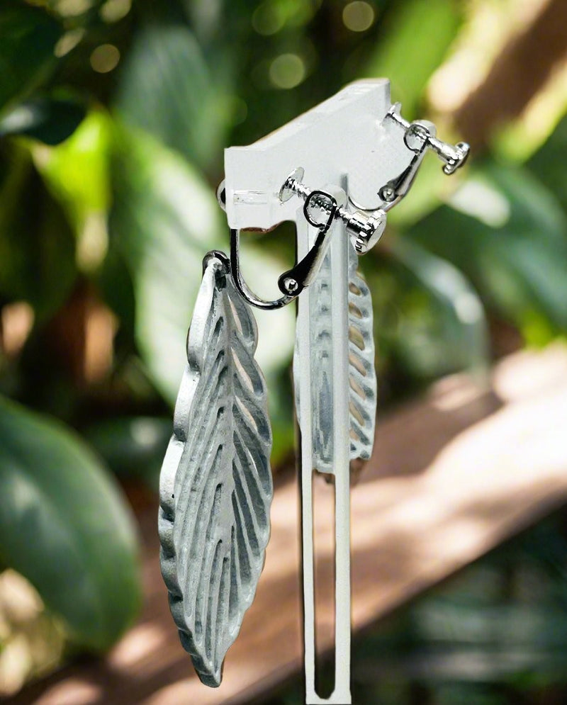 Clip on 2 1/2" silver and white cutout leaf dangle earrings