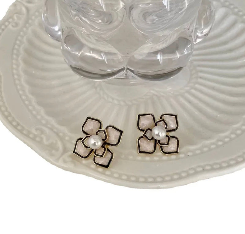 Vintage clip on 1" gold, white flower earrings with black trim and center pearl