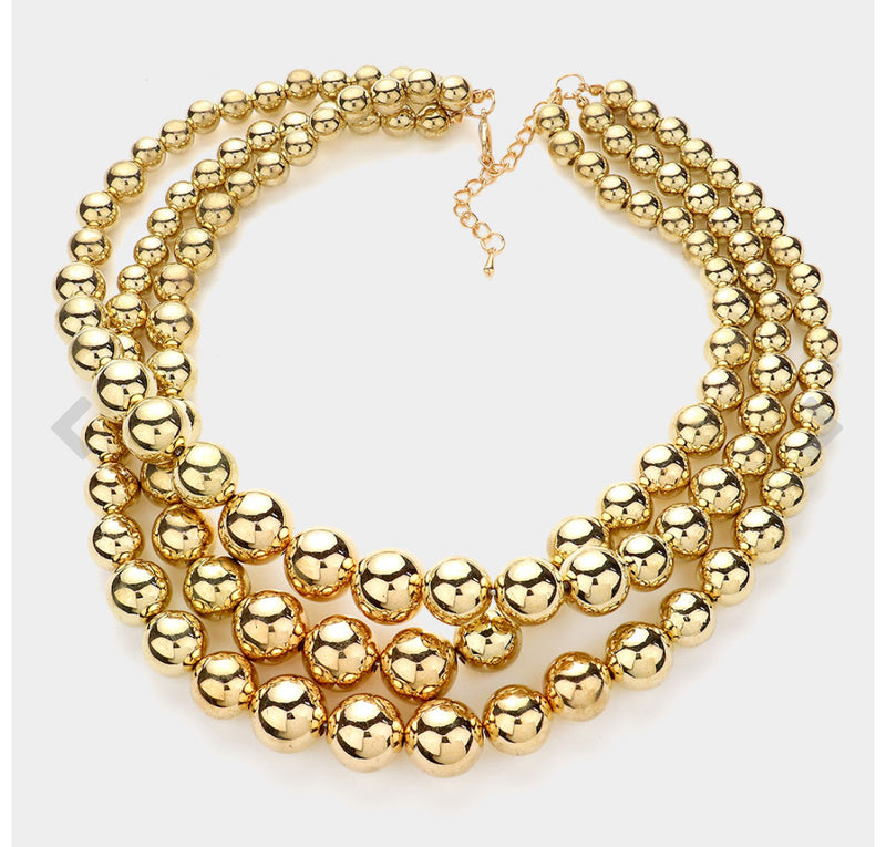Pierced shiny gold three layered necklace and earring set