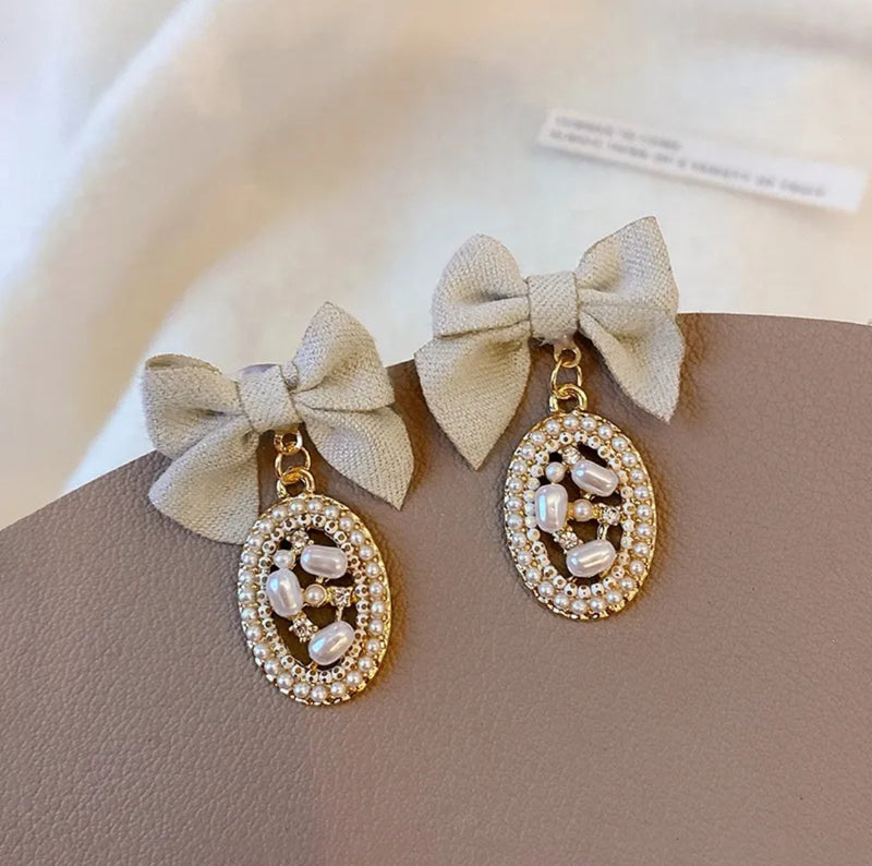 Clip on 1 1/2" gold, tan bow, and pearl edge dangle earrings