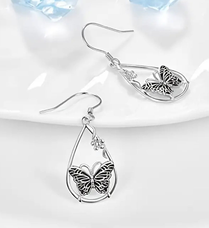 Pierced 1 3/4" silver teardrop earrings with center butterfly