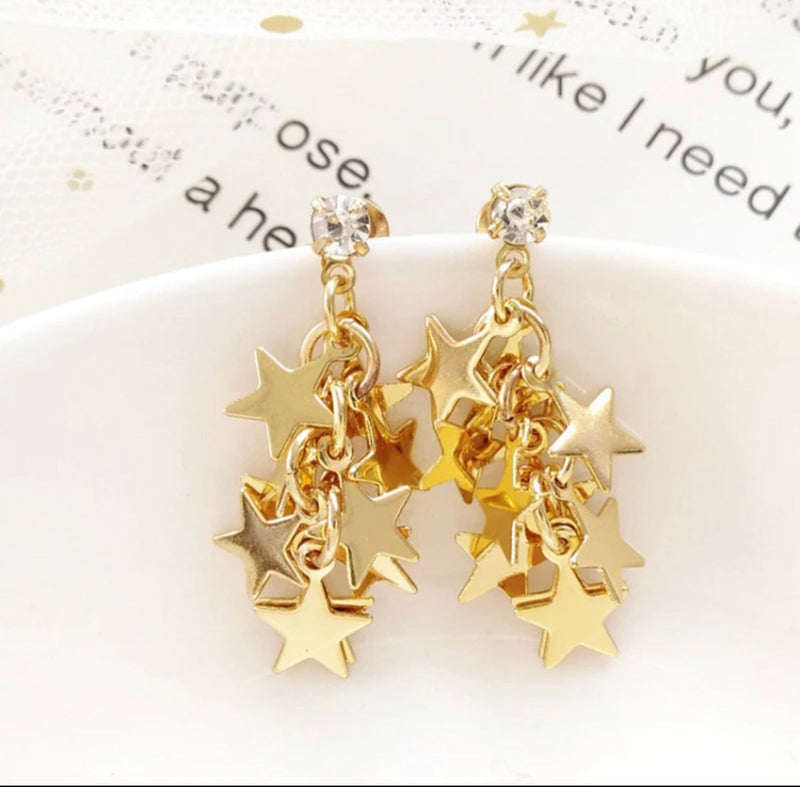 Clip on 1 1/2" gold and clear stone dangle star cluster earrings