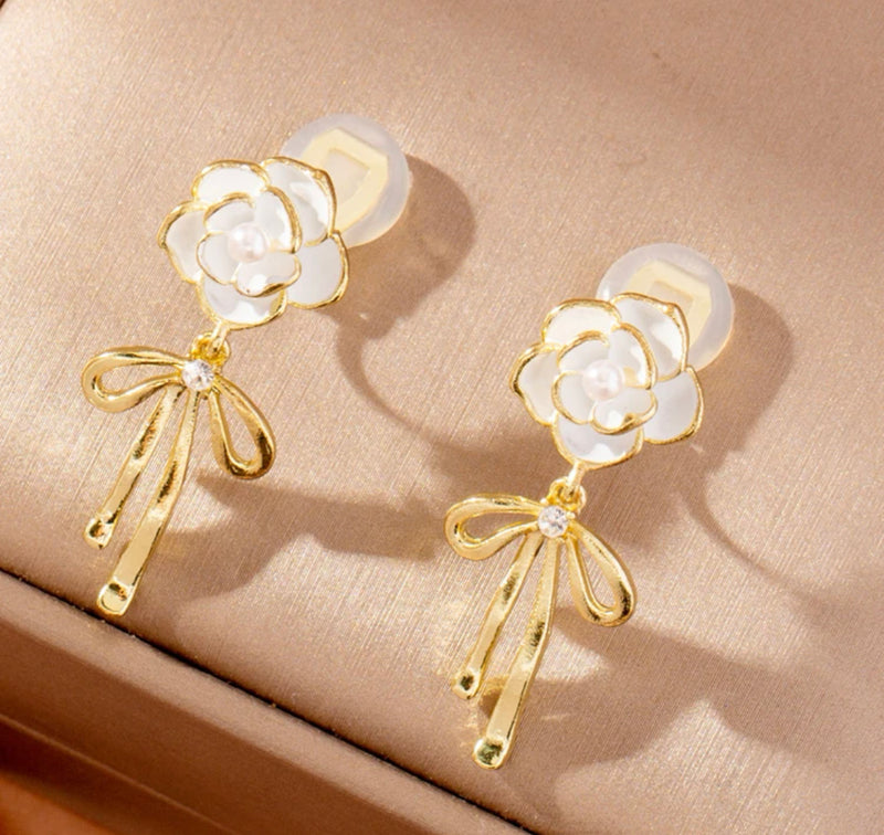 Clip on 1 1/2" gold and white flower earrings with dangle bow and pearl