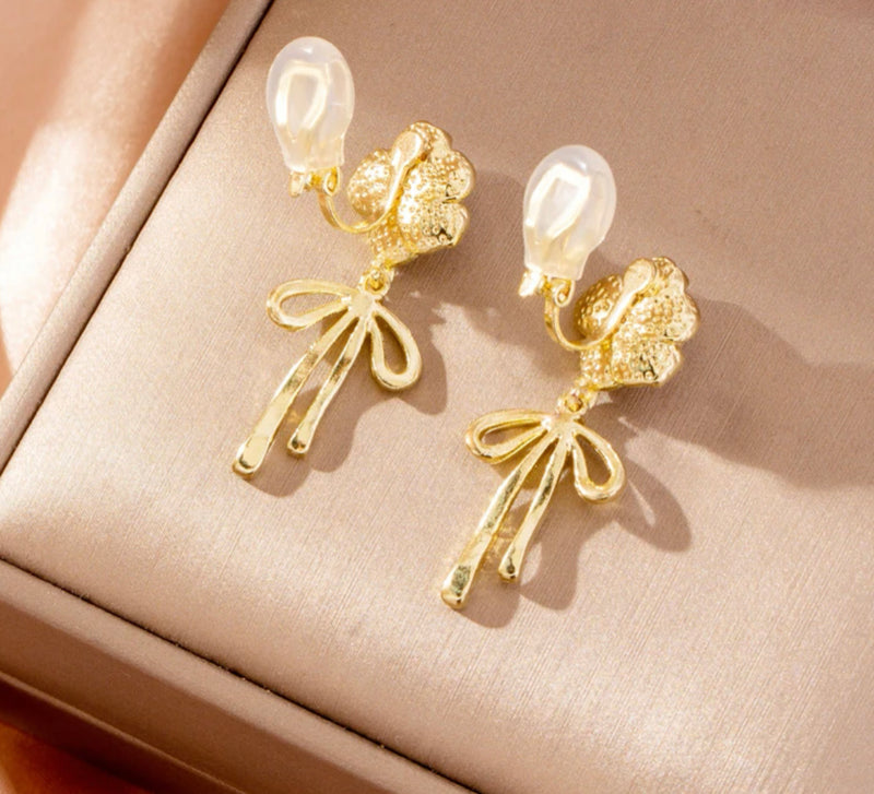 Clip on 1 1/2" gold and white flower earrings with dangle bow and pearl