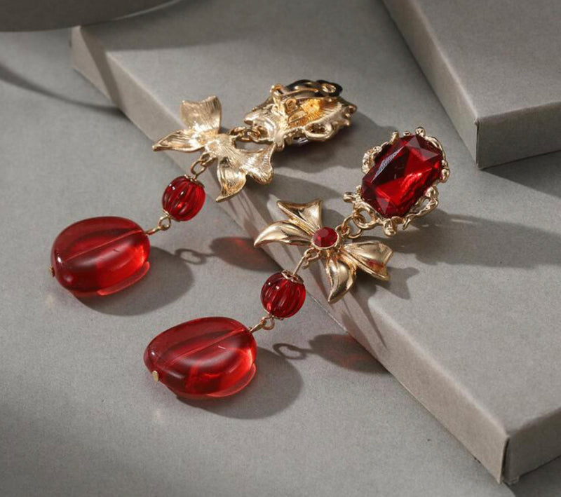 Clip on 3 1/2" gold and red stone dangle bow earrings with red dangle bead