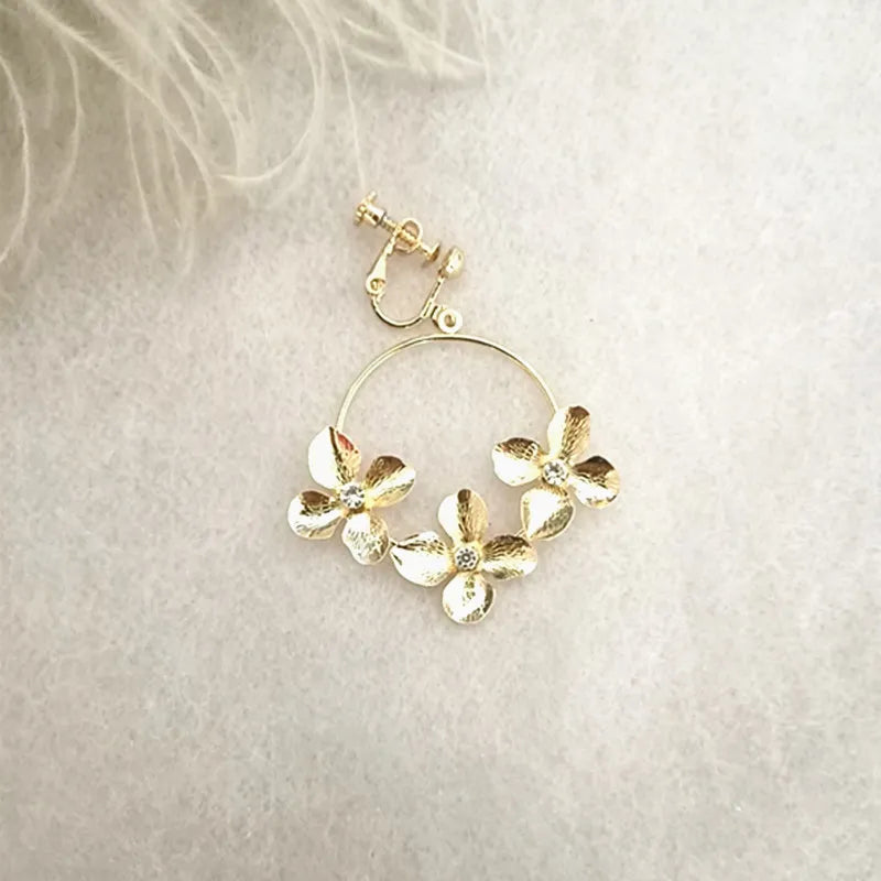 Clip on 2" gold hoop earrings with flowers and clear center stone
