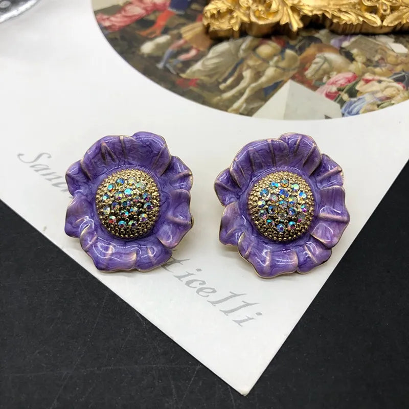 Clip on 1 1/4" gold and purple flower earrings with fluorescent stones