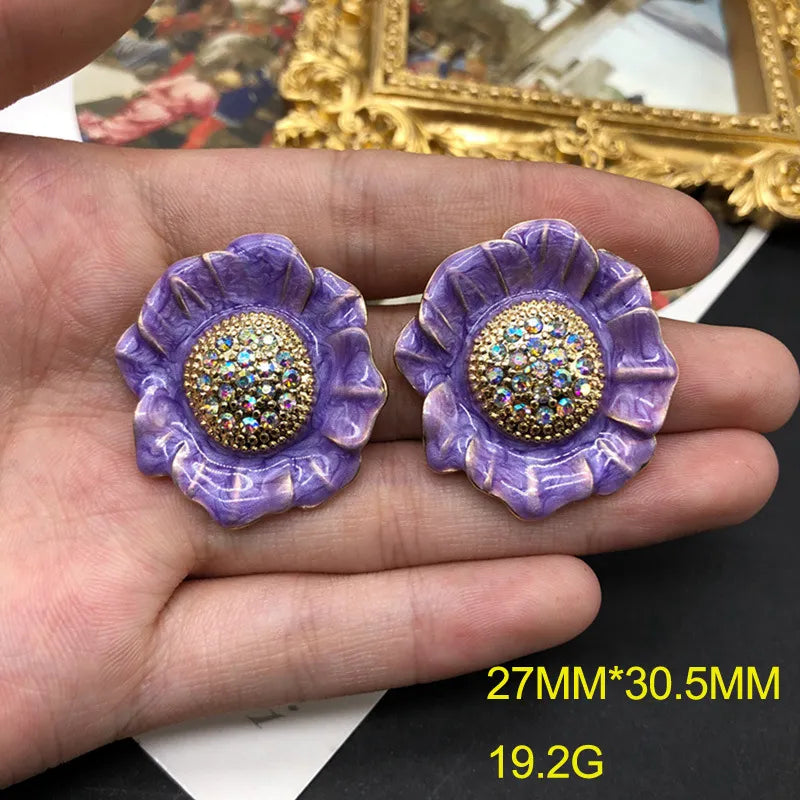 Clip on 1 1/4" gold and purple flower earrings with fluorescent stones