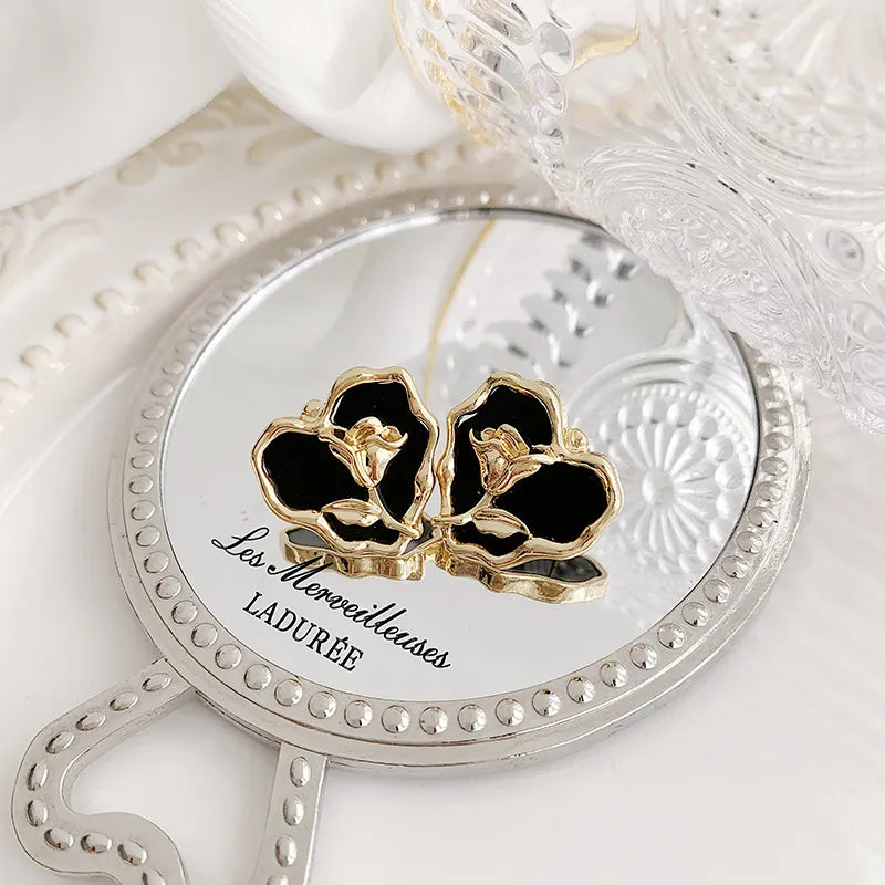 Clip on 1" gold and black heart earrings with center flower