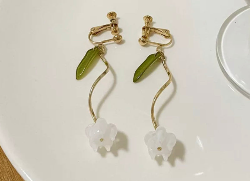 Clip on 2 3/4" gold wire, green, & white flower dangle earrings