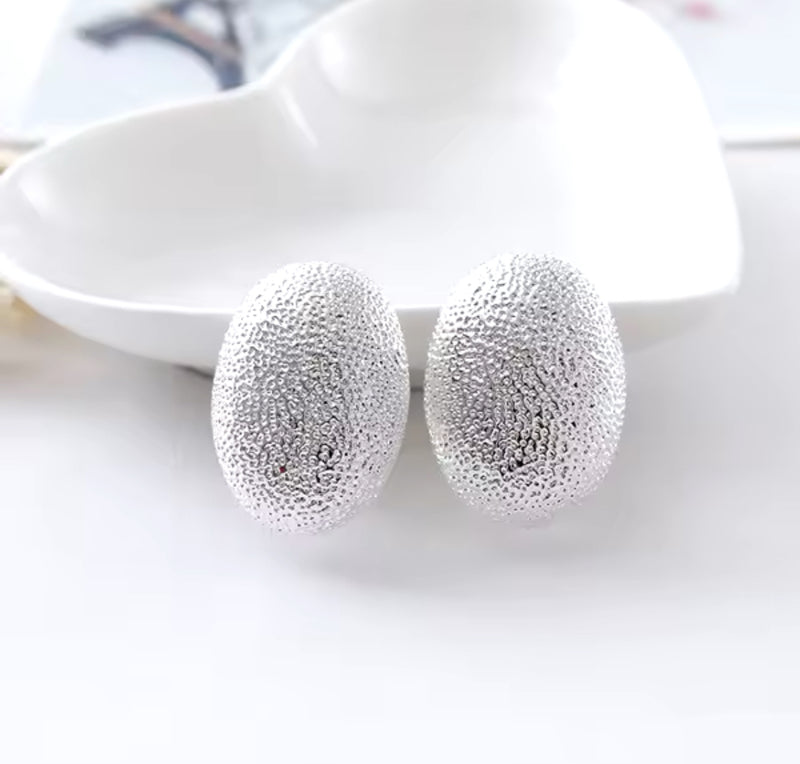 Clip on 1 1/4" silver textured oval button style earrings