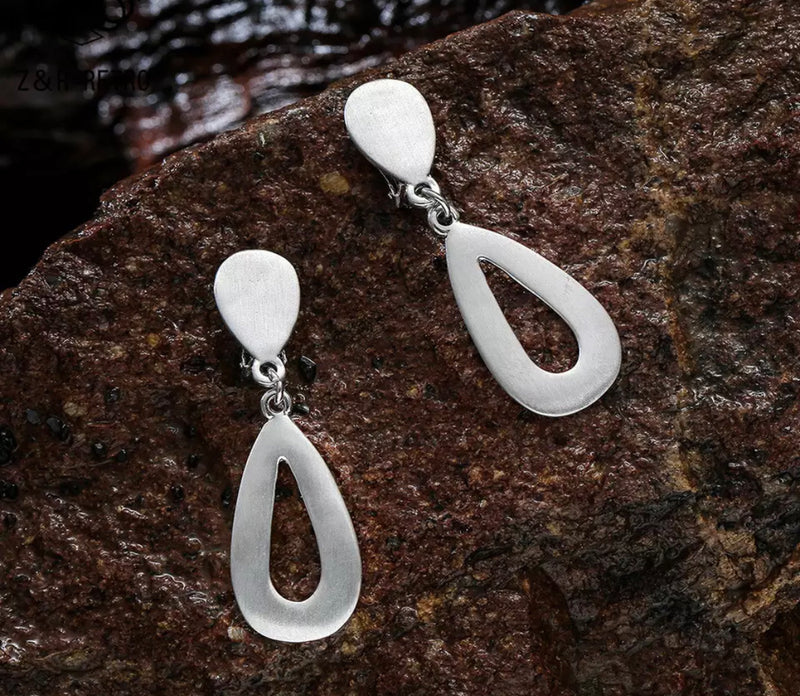 Clip on 2 1/4" matte silver cutout double teardrop dangle earrings