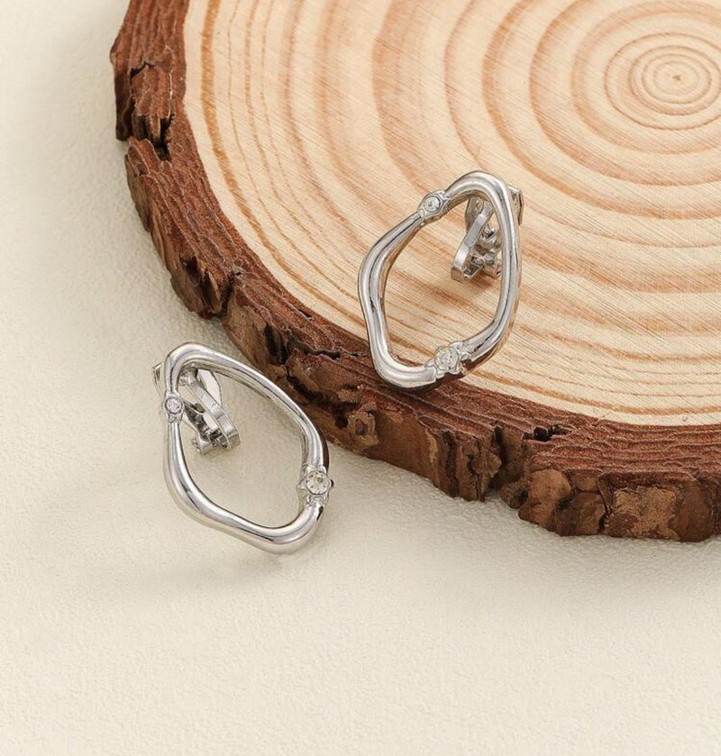 Clip on 1" silver odd shaped cutout oval earrings w/clear stone