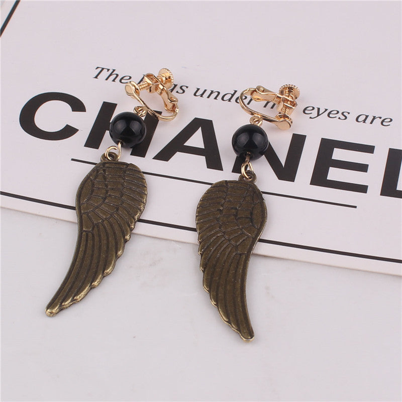 Clip on 2 3/4" brass dangle wing earrings with black bead