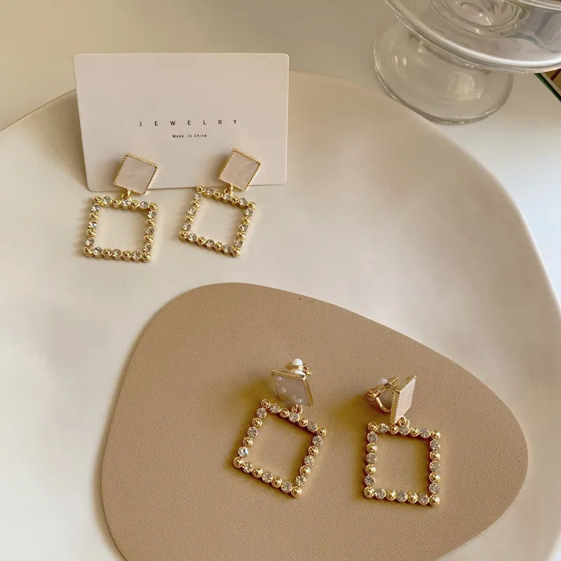 Clip on 1 3/4" gold, white and clear stone dangle square earrings