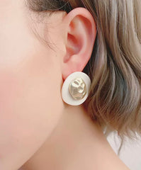 Clip on matte gold wavy white button style earrings