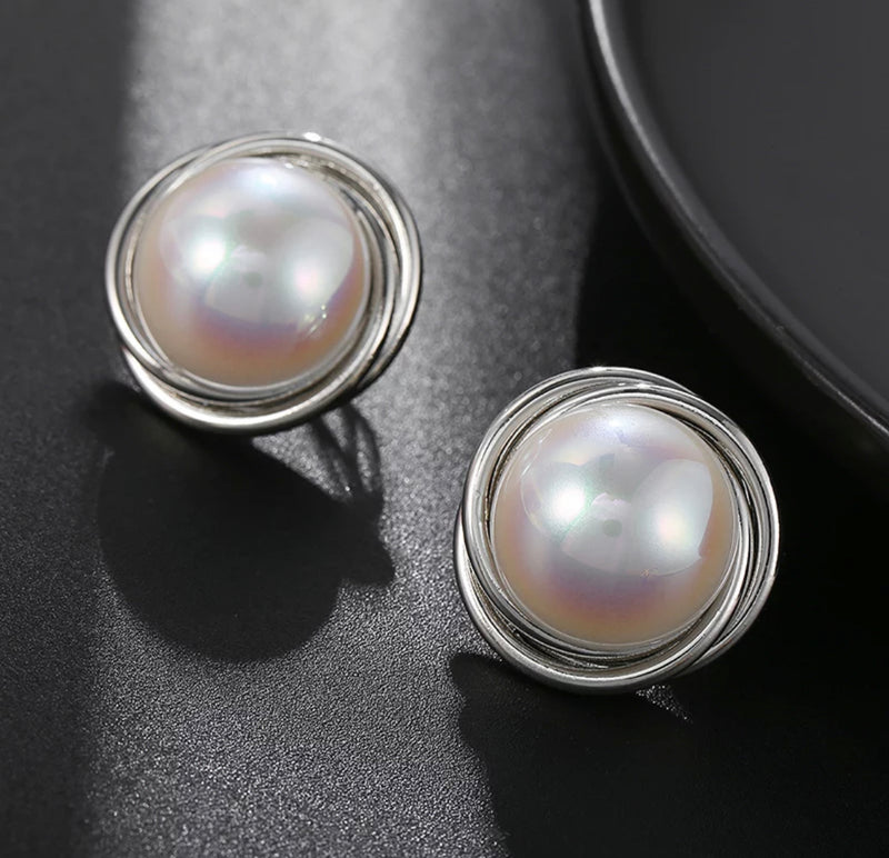 Clip on 1" silver and fluorescent tint pearl earrings with twisted edges