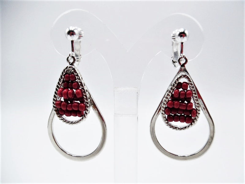 Clip on 2 1/4" silver teardrop dangle earrings with red seed beads in the center