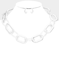 Pierced matte silver necklace and earring set with clear link